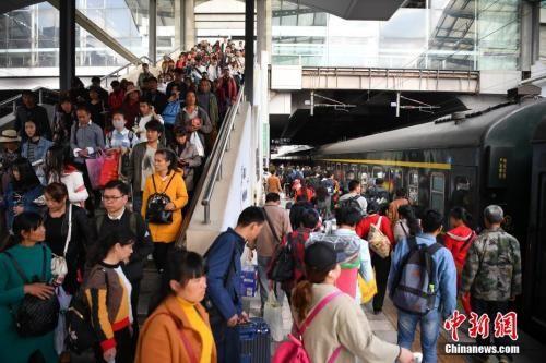 资料图：2018年3月12日，旅客在昆明火车站进站乘车。中新社记者 刘冉阳 摄