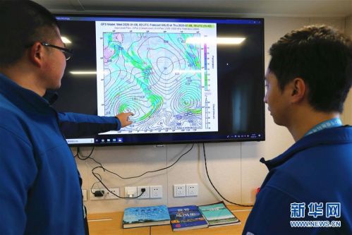 1月9日，“雪龙2”号气象预报员张守文（左）与郭安博宇在过西风带前研判天气形势。新华社记者 刘诗平 摄
