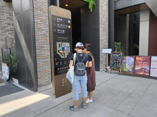 两位游客在指示牌前寻找美食门店
