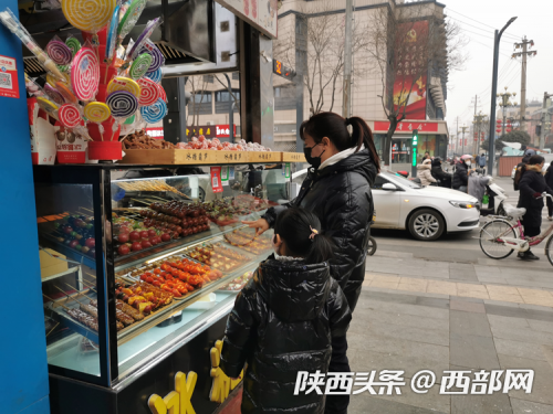 顾客给孩子购买冰糖葫芦。