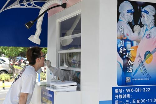 7月5日，在无锡市滨湖区蠡园街道的一处核酸采样点，一名市民在进行核酸采样。新华社记者 李博 摄