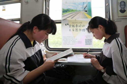 学生旅客正在6063次公益慢火车上进行学习。（张雁南 摄）